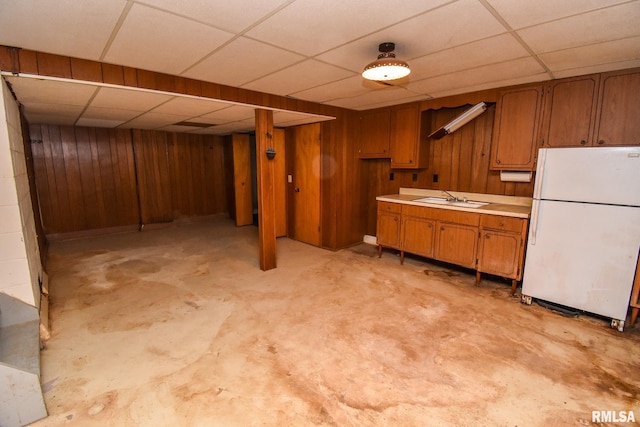 1602 Highwood Ave, Pekin, IL 61554 - kitchen with freestanding refrigerator, a paneled ceiling, brown cabinets, light countertops, and unfinished concrete flooring