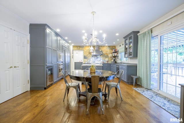 512 Hidden Ln, Peoria, IL 61614 - dining space featuring beverage cooler, a chandelier, plenty of natural light, ornamental molding, and wood finished floors