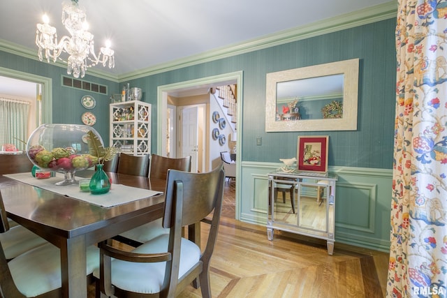 512 Hidden Ln, Peoria, IL 61614 - dining room featuring a chandelier, light wood-type flooring, wainscoting, crown molding, and stairs