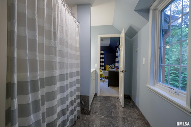512 Hidden Ln, Peoria, IL 61614 - full bath with healthy amount of natural light, vanity, a shower with curtain, and vaulted ceiling