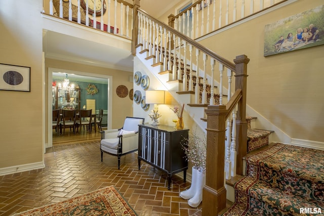 512 Hidden Ln, Peoria, IL 61614 - staircase with a chandelier, ornamental molding, and brick floors