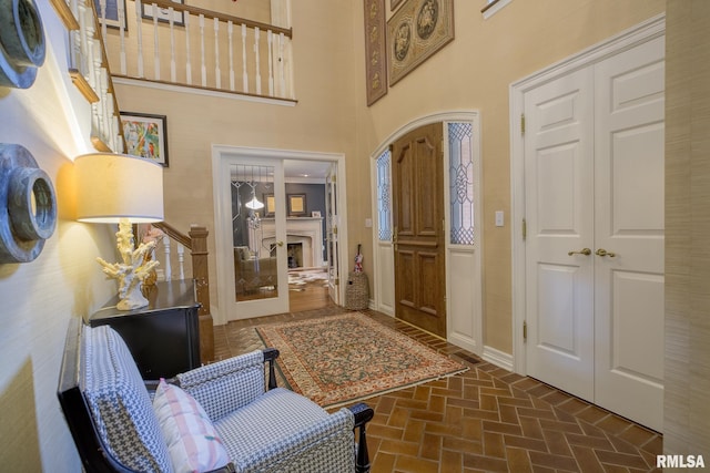 512 Hidden Ln, Peoria, IL 61614 - entryway featuring brick floors, a fireplace, and a towering ceiling