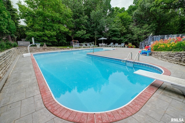 512 Hidden Ln, Peoria, IL 61614 - outdoor pool with a patio area, a diving board, and view of wooded area