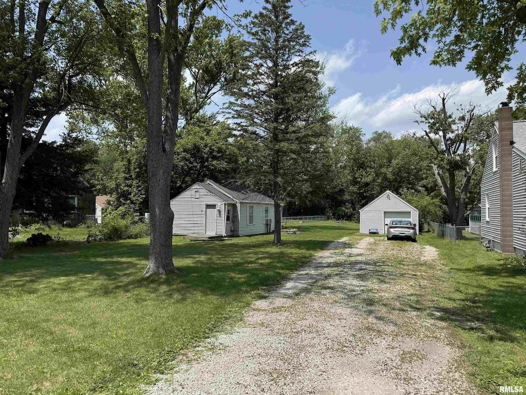 5217 W Monroe Rd, Bartonville, IL 61607 - view of grassy yard with dirt driveway, an outbuilding, and a garage