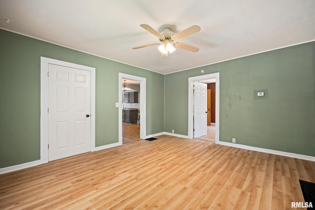 1013 N 2nd St, Pekin, IL 61554 - unfurnished bedroom featuring light wood-type flooring, connected bathroom, and ceiling fan