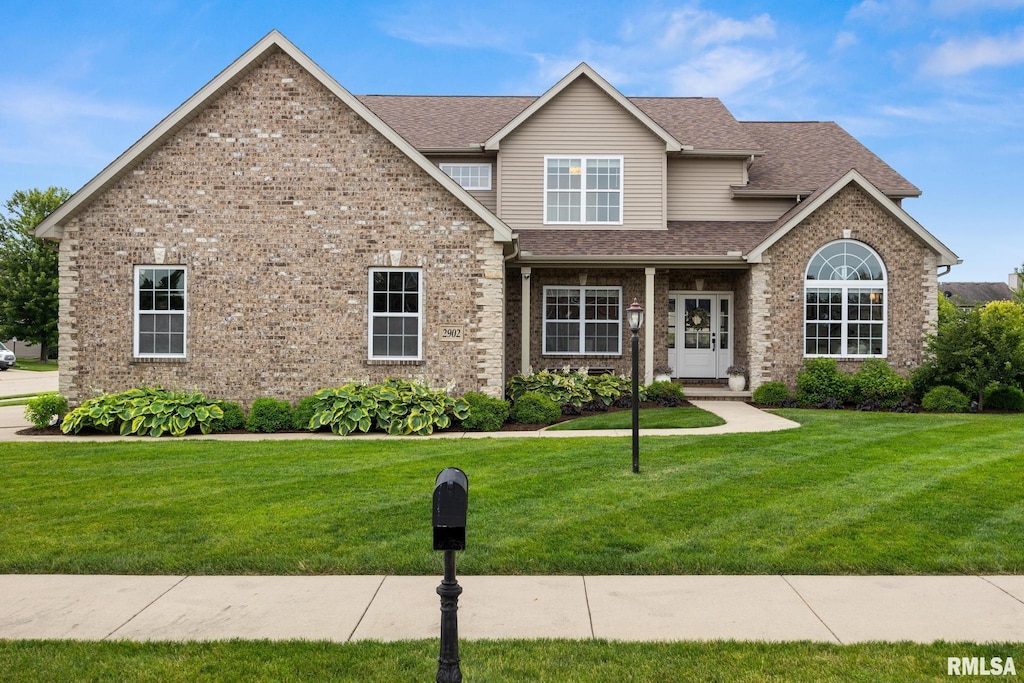 2902 W Wessex Dr, Peoria, IL 61615 - view of front facade featuring a front lawn, roof with shingles, and brick siding