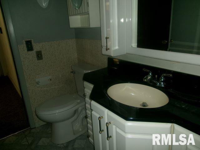 102 N Park Ave, Manito, IL 61546 - bathroom featuring vanity, tile walls, and a wainscoted wall