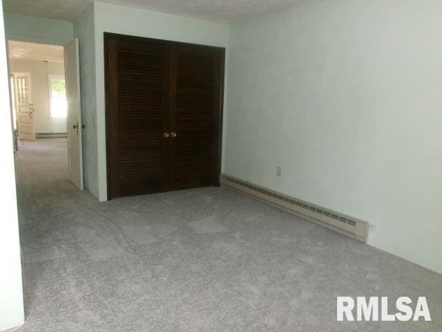 102 N Park Ave, Manito, IL 61546 - unfurnished bedroom featuring baseboard heating and carpet flooring