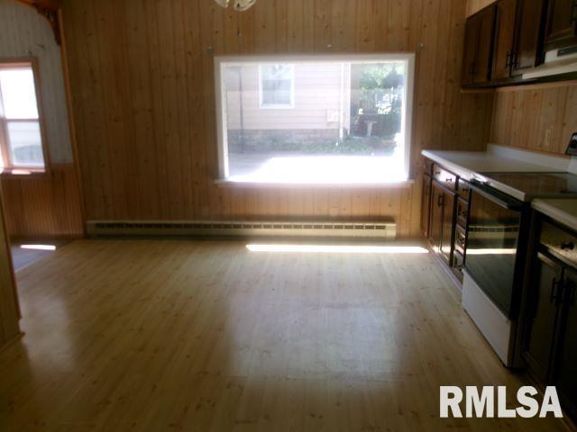 102 N Park Ave, Manito, IL 61546 - kitchen with white electric stove, wooden walls, healthy amount of natural light, light wood finished floors, and light countertops