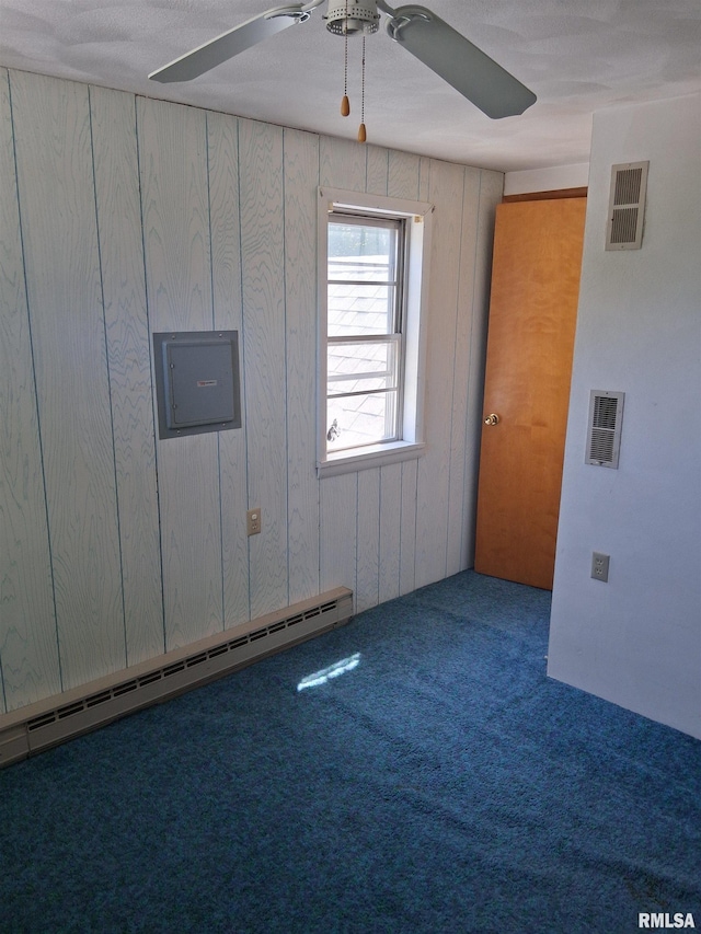 102 N Park Ave, Manito, IL 61546 - carpeted spare room featuring ceiling fan, a baseboard heating unit, electric panel, and wood walls