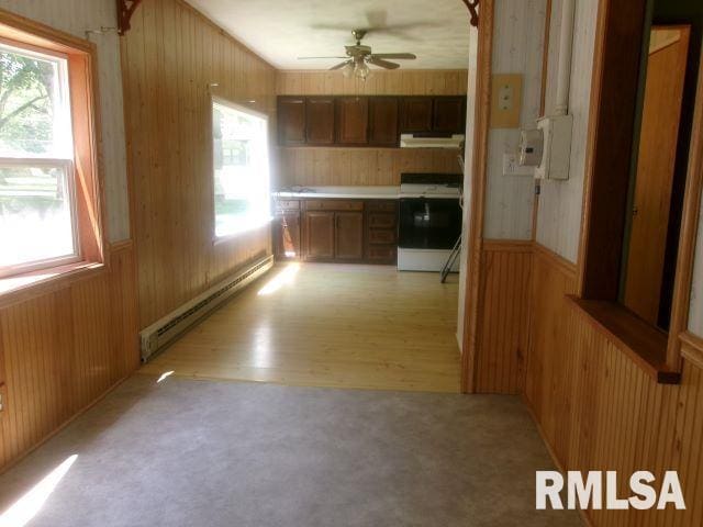 102 N Park Ave, Manito, IL 61546 - hall with baseboard heating, wooden walls, healthy amount of natural light, wainscoting, and light wood-type flooring
