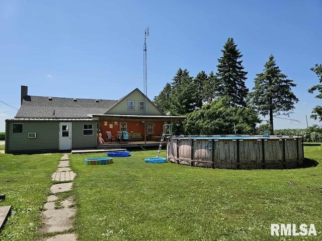 19635 E 800th St, Sciota, IL 61475 - back of property featuring a lawn, an outdoor pool, and roof with shingles