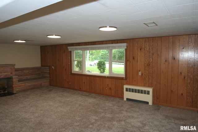 29724 Allentown Rd, Mackinaw, IL 61755 - unfurnished living room featuring radiator, carpet, wooden walls, and a fireplace