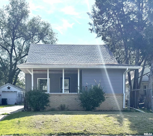 1406 6th St, Pekin, IL 61554 - view of front of house featuring an outdoor structure, covered porch, a garage, brick siding, and a shingled roof