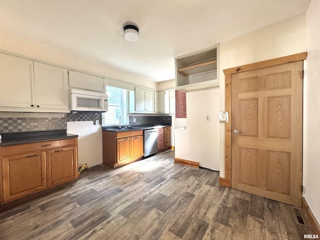 1406 6th St, Pekin, IL 61554 - kitchen with white microwave, dishwasher, dark wood finished floors, decorative backsplash, and dark countertops