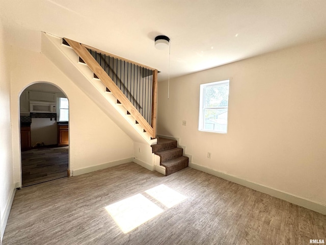 1406 6th St, Pekin, IL 61554 - staircase with wood finished floors, arched walkways, and healthy amount of natural light