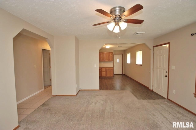 1409 Alton St, Pekin, IL 61554 - unfurnished living room featuring arched walkways, ceiling fan, carpet flooring, and a textured ceiling