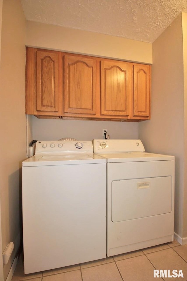 1409 Alton St, Pekin, IL 61554 - laundry room with cabinet space, washing machine and dryer, light tile patterned flooring, and a textured ceiling