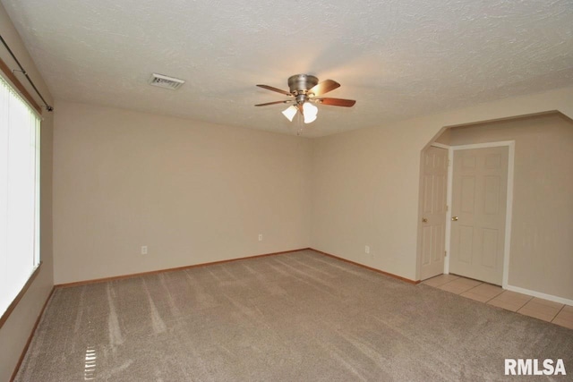 1409 Alton St, Pekin, IL 61554 - unfurnished room with light colored carpet, a ceiling fan, arched walkways, and a textured ceiling