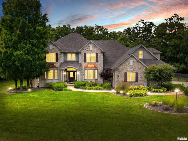 4851 Sheridan Rd, Groveland, IL 61535 - view of front facade with stone siding, a front lawn, and a shingled roof