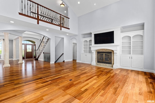 4851 Sheridan Rd, Groveland, IL 61535 - unfurnished living room with ornate columns, wood finished floors, arched walkways, a high end fireplace, and high vaulted ceiling