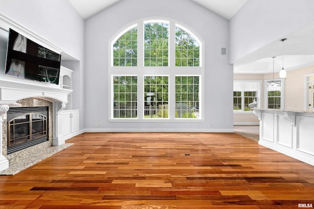 4851 Sheridan Rd, Groveland, IL 61535 - unfurnished living room featuring high vaulted ceiling, wood finished floors, healthy amount of natural light, and a high end fireplace