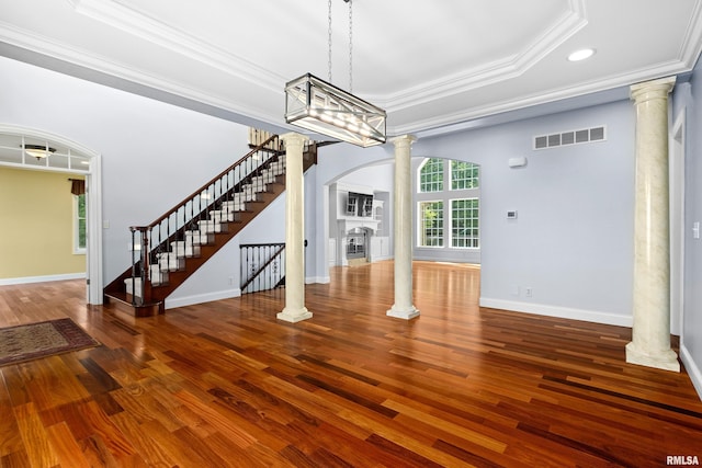 4851 Sheridan Rd, Groveland, IL 61535 - unfurnished dining area featuring decorative columns, arched walkways, a raised ceiling, ornamental molding, and a fireplace