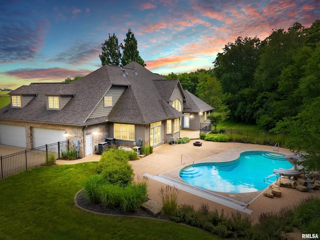 4851 Sheridan Rd, Groveland, IL 61535 - pool at dusk featuring a fenced backyard, a patio area, and a water slide