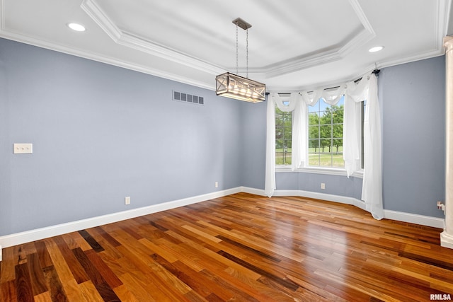 4851 Sheridan Rd, Groveland, IL 61535 - empty room with a raised ceiling, crown molding, recessed lighting, wood finished floors, and a chandelier