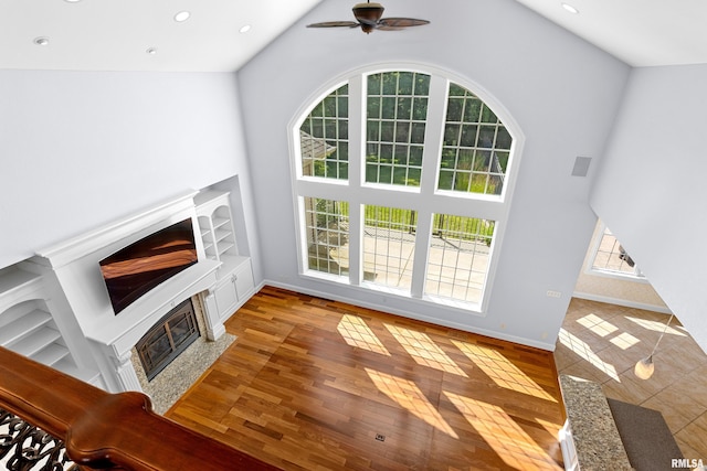 4851 Sheridan Rd, Groveland, IL 61535 - unfurnished living room with a glass covered fireplace, plenty of natural light, high vaulted ceiling, a ceiling fan, and recessed lighting