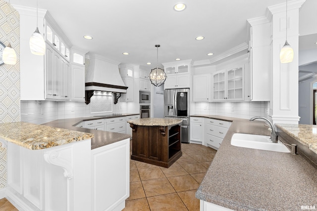 4851 Sheridan Rd, Groveland, IL 61535 - kitchen with appliances with stainless steel finishes, custom range hood, a peninsula, backsplash, and white cabinets