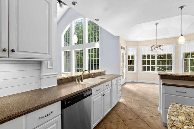 4851 Sheridan Rd, Groveland, IL 61535 - kitchen with stainless steel dishwasher, healthy amount of natural light, white cabinetry, and hanging light fixtures