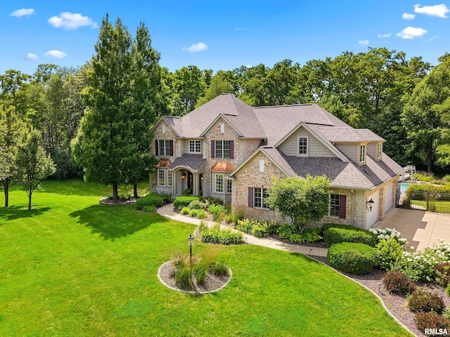 4851 Sheridan Rd, Groveland, IL 61535 - view of front facade with concrete driveway, stone siding, a shingled roof, and an attached garage