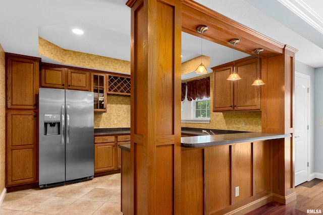 4851 Sheridan Rd, Groveland, IL 61535 - kitchen with stainless steel fridge, brown cabinets, dark countertops, backsplash, and glass insert cabinets