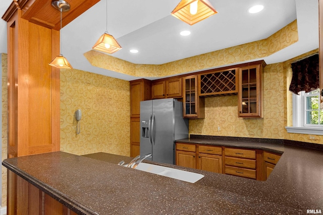 4851 Sheridan Rd, Groveland, IL 61535 - kitchen featuring stainless steel fridge, wallpapered walls, dark countertops, glass insert cabinets, and hanging light fixtures