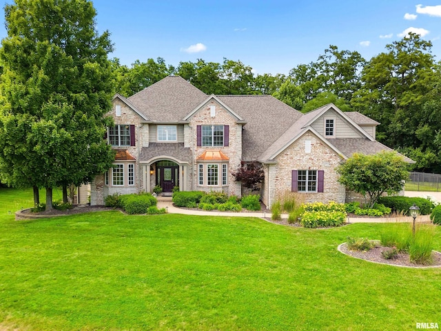 4851 Sheridan Rd, Groveland, IL 61535 - view of front of house featuring stone siding, a front lawn, and a shingled roof