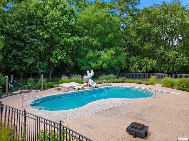 4851 Sheridan Rd, Groveland, IL 61535 - view of pool featuring a water slide, a patio area, and view of wooded area