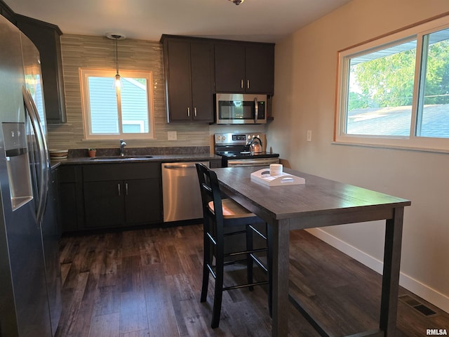 1704 Heisel Ave, Pekin, IL 61554 - kitchen featuring appliances with stainless steel finishes, dark countertops, dark wood-type flooring, and decorative light fixtures
