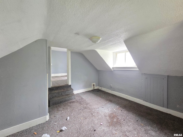 2011 N Bigelow St, Peoria, IL 61604 - additional living space featuring a textured ceiling, vaulted ceiling, and stairway