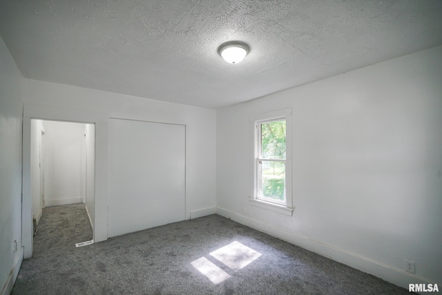 2320 W Krause Ave, Peoria, IL 61605 - unfurnished bedroom with carpet, a textured ceiling, and a closet