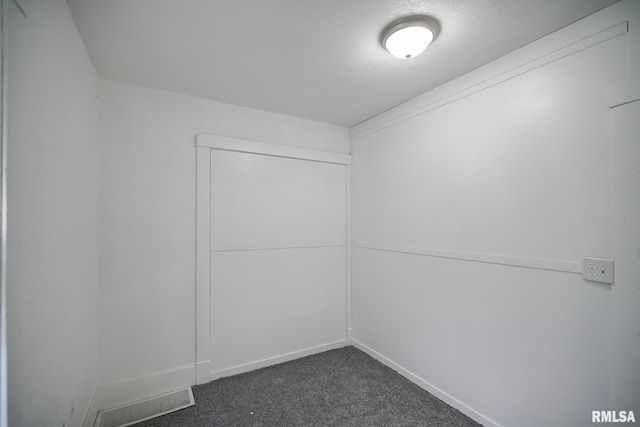 2320 W Krause Ave, Peoria, IL 61605 - empty room featuring dark colored carpet and baseboards