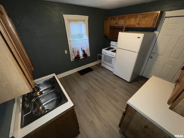 909 W Mcclure Ave, Peoria, IL 61604 - kitchen featuring white appliances, dark wood-style floors, light countertops, and brown cabinets