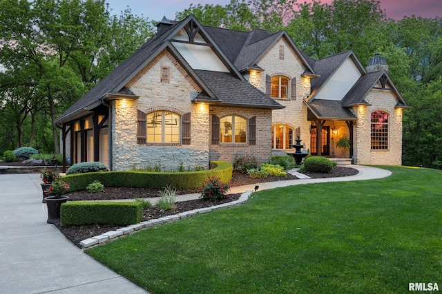 2204 W Pinnacle Dr, Dunlap, IL 61525 - french provincial home with stone siding, a chimney, concrete driveway, and a yard