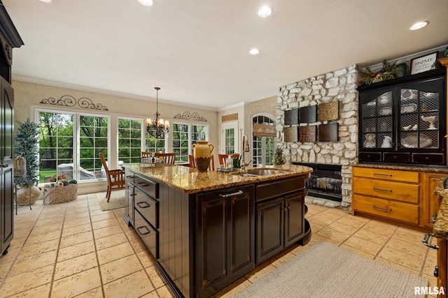 2204 W Pinnacle Dr, Dunlap, IL 61525 - kitchen featuring a center island with sink, a fireplace, a chandelier, stone counters, and recessed lighting