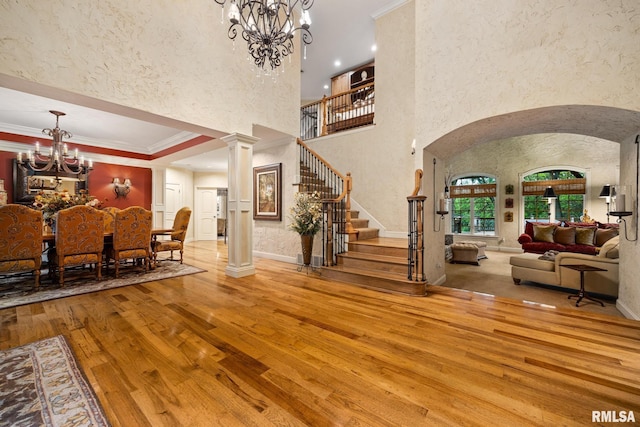 2204 W Pinnacle Dr, Dunlap, IL 61525 - foyer entrance with wood-type flooring, a chandelier, arched walkways, stairs, and crown molding