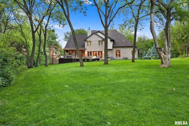 2204 W Pinnacle Dr, Dunlap, IL 61525 - back of house with a chimney, a yard, stone siding, and a deck