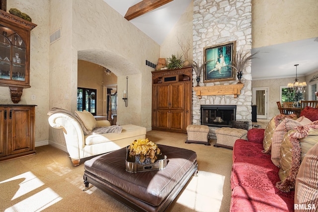 2204 W Pinnacle Dr, Dunlap, IL 61525 - living area with light carpet, a stone fireplace, arched walkways, high vaulted ceiling, and a chandelier