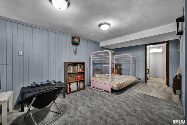 2816 N Kingston Dr, Peoria, IL 61604 - bedroom with wood walls, carpet floors, and a textured ceiling