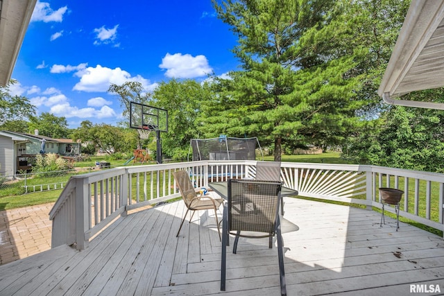 2816 N Kingston Dr, Peoria, IL 61604 - wooden deck featuring a trampoline, a playground, a lawn, and view of scattered trees
