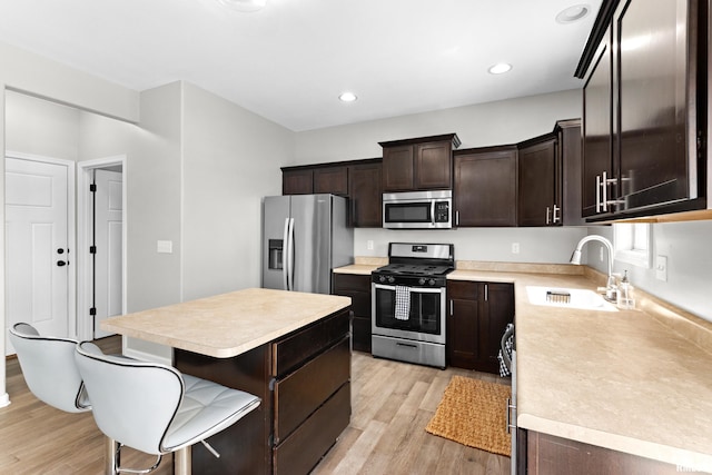 1604 Savile Ln, Washington, IL 61571 - kitchen featuring appliances with stainless steel finishes, light countertops, light wood-style floors, dark brown cabinetry, and a kitchen island
